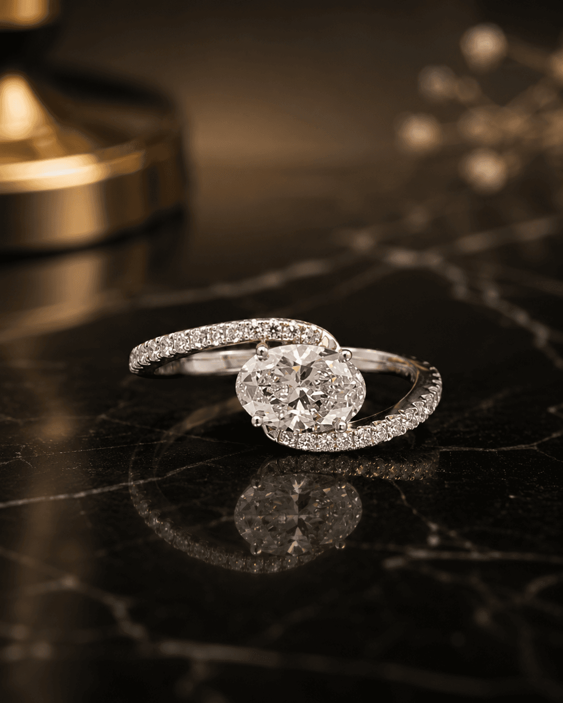 East-west set oval lab-grown diamond ring in white gold with a bypass pavé band, on black marble.